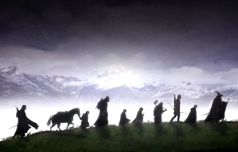 Lord of the Rings poster featuring iconic characters walking towards the sun behind a mountain.